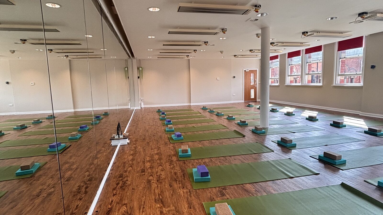 The Hot Studio at Deansgate Haus, set up with mats and blocks along the mirror wall