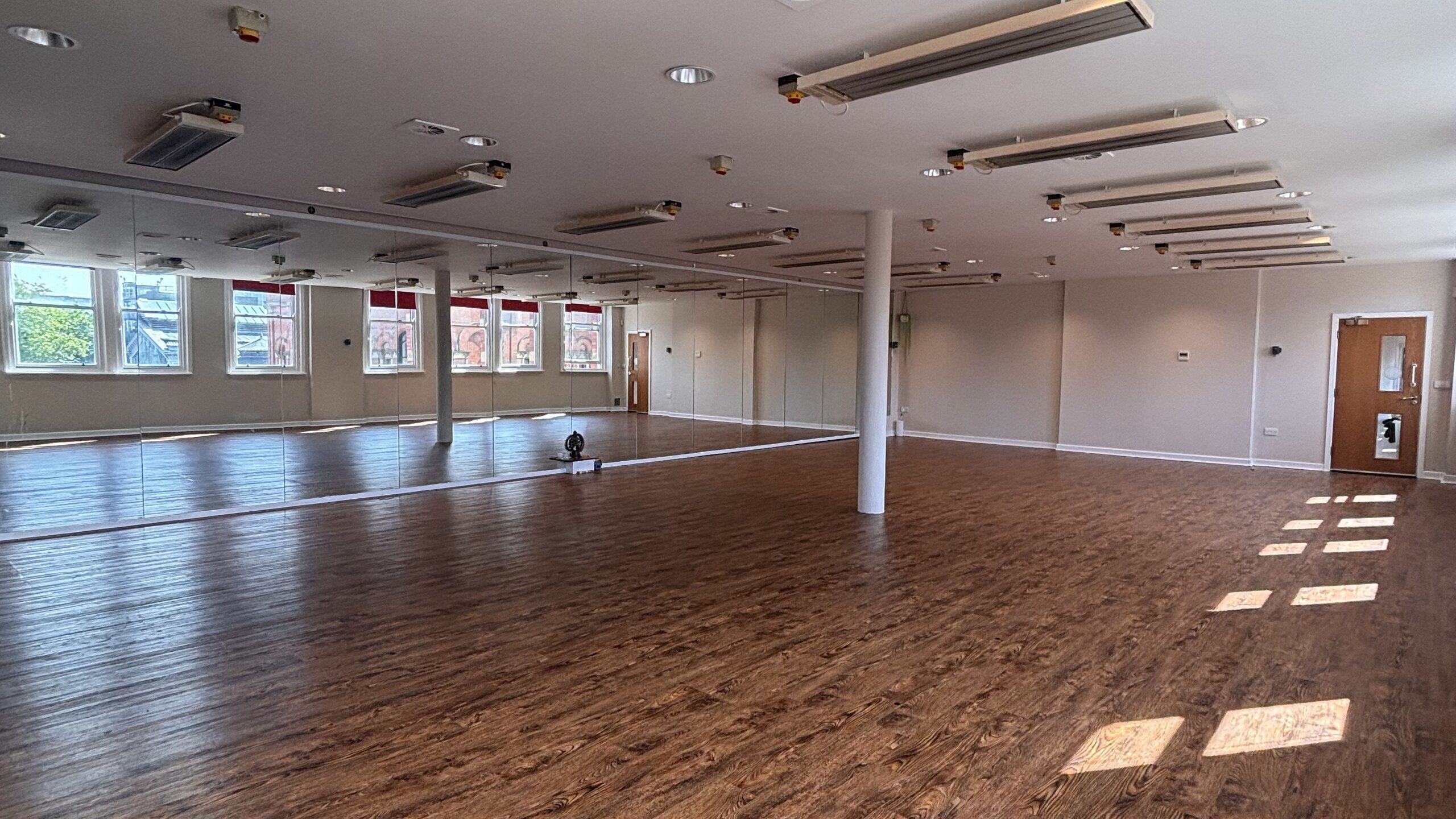 The Hot Studio at Deansgate Haus, empty, with infrared heaters overhead and a wood floor